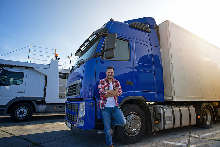 Logistik im CCH Mann lehnt an blauem LKW