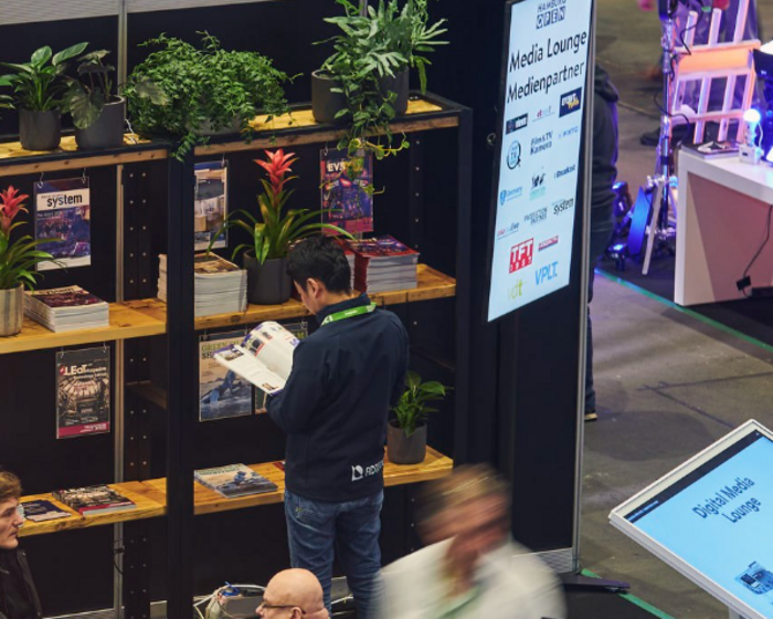 Ein Mann steht am Zeitschriftenregal der Media Lounge.