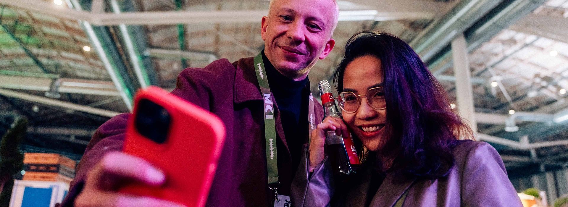 A man and a woman look at a smartphone together.