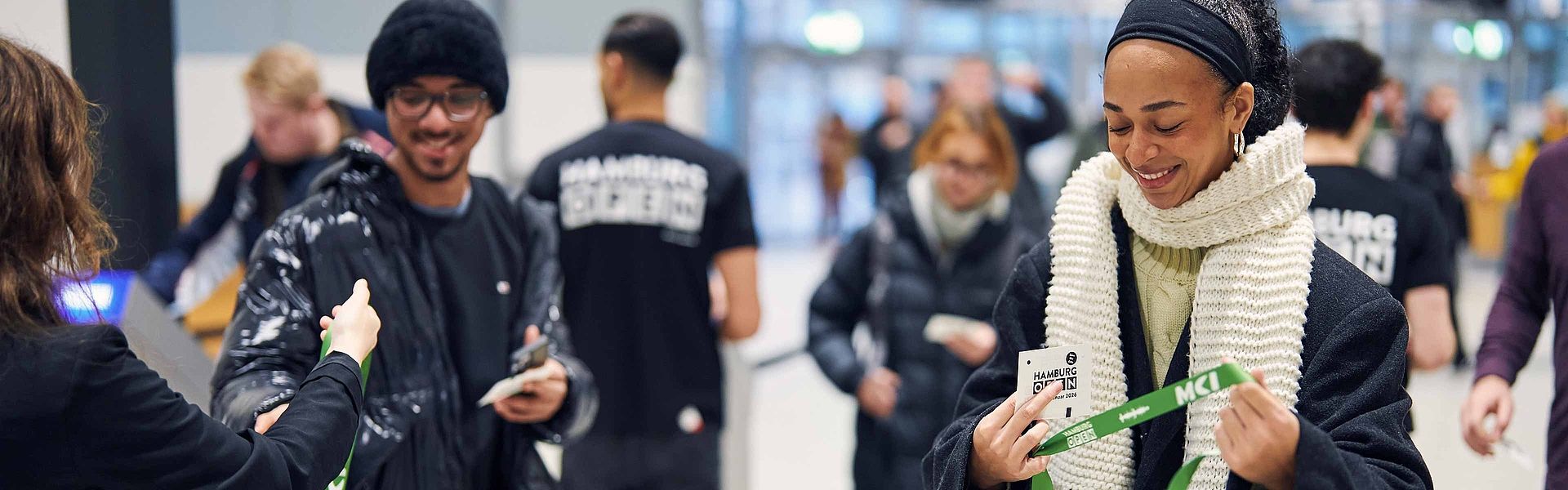 Besucherin und Besucher erhalten grüne Lanyards für ihre HAMBURG OPEN Tickets.