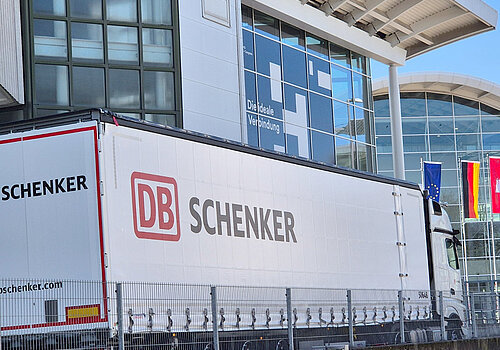 LKW mit der Aufschrift "DB Schenker" vor den Messehallen