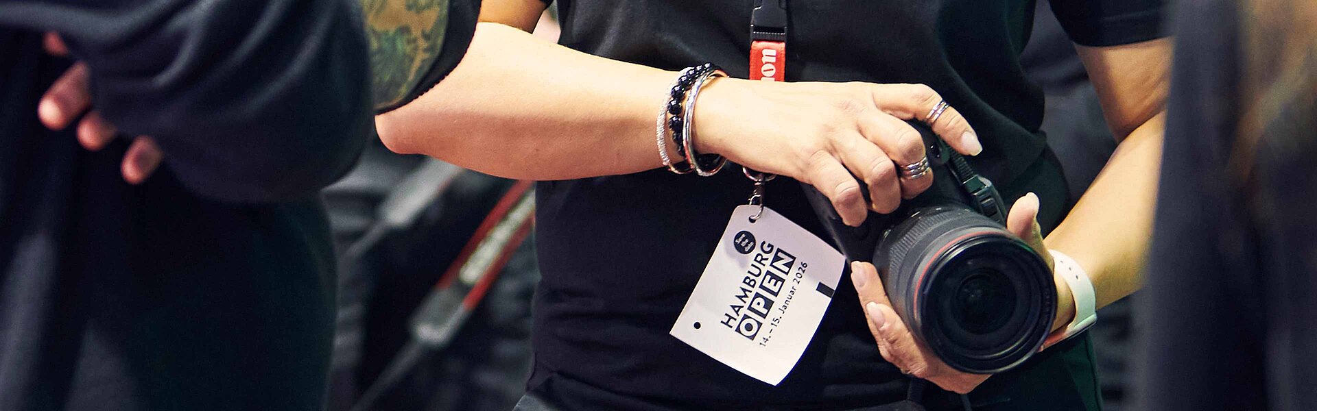 Bildausschnitt zeigt die Arme einer Frau, die eine Kamera in den Händen hält.